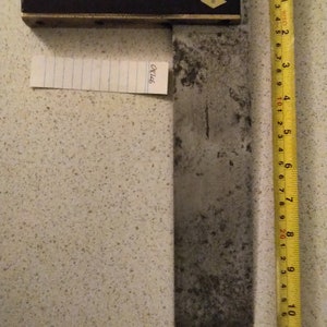 May include: A vintage metal try square with a wooden handle. The handle has a brass inlay and two diamond-shaped inlays. The try square is 28 cm long.