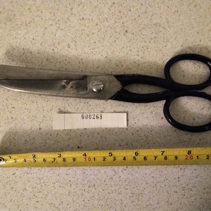 May include: A pair of large, black-handled shears with a silver blade. The shears are 9 inches long and have a label with the number 000268 on it.