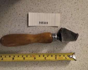 May include: A wooden handled glass cutter with a metal blade. The blade has a sharp edge and is designed to cut glass. The handle is made of wood and has a comfortable grip. The cutter is about 7 inches long.