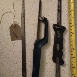 May include: Three hand saws, one with a blue handle, one with a black handle, and one with a brown handle. The saws are all approximately 30 cm long.