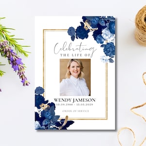 May include: A funeral programme card featuring a white background with a gold rectangular border, dark blue floral illustrations, and a central photograph of a person. Text reads: Celebrating THE LIFE OF WENDY JAMESON 10.09.1988 - 15.05.2029 ORDER OF SERVICE.