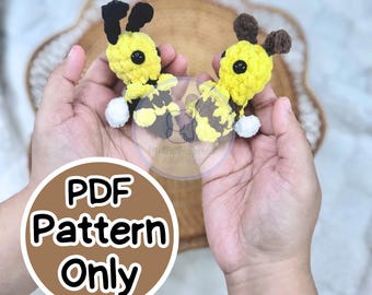 May include: Two handmade crochet bee toys. The bees are yellow with black and brown accents, and white pom-pom feet. The image includes a circular graphic that says "PDF Pattern Only".