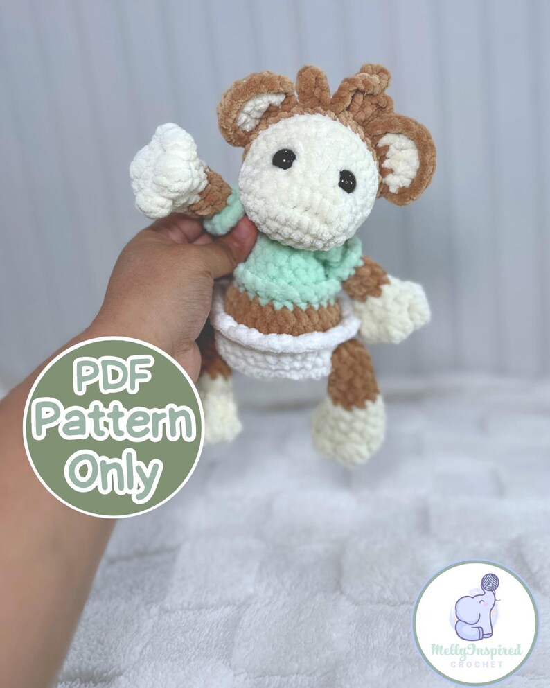 May include: A crochet pattern for a brown and white monkey wearing a green shirt and a white diaper. The pattern is available as a PDF download. The text "PDF Pattern Only" is written in a green circle.