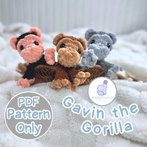 Op de afbeelding: Drie gehaakte gorilla-speeltjes in roze, bruin en grijs, elk met zwarte ogen en kleine armen. De speeltjes zitten op een geweven mand, met de tekst "Gavin the Gorilla" en "PDF Pattern Only" in de afbeelding.