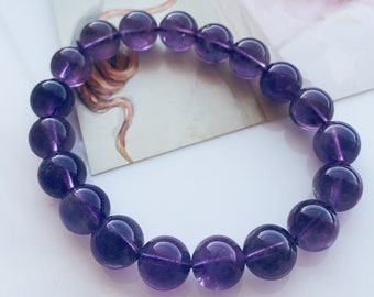 May include: A purple amethyst gemstone bracelet with round beads.