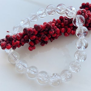 May include: A clear crystal bracelet with faceted beads. The bracelet is made of natural quartz and has a delicate, elegant look.