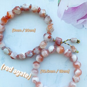 May include: Two red agate bracelets. The larger bracelet has round beads and measures 10.5mm in diameter and 18cm in length. The smaller bracelet has faceted beads and measures 9mm in diameter and 20cm in length.
