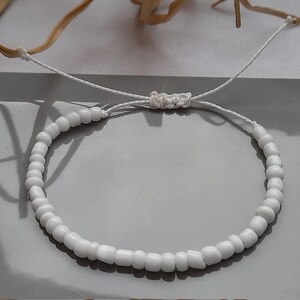 Puede incluir: Pulsera de cuentas blancas con cierre de cord&oacute;n blanco.