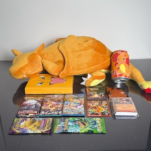 Die Pokémon-Sammelkartenspiel-Box mit Glurak-Thema enthält Booster Packs, Plüschtiere, Soda und mehr