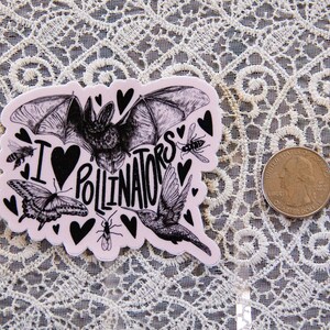 May include: A pink sticker with a black and white illustration of a bat, hummingbird, butterfly, and bees. The sticker says "I love pollinators" with a heart in place of the "O".
