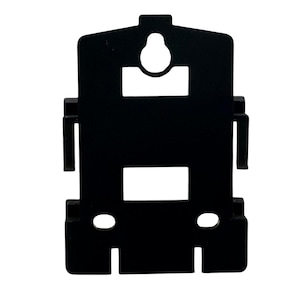 May include: A black plastic wall mounting bracket featuring a central keyhole slot at the top, two rectangular cutouts, and two smaller circular holes at the bottom. The bracket has side clips and a flat, rectangular design for secure installation.