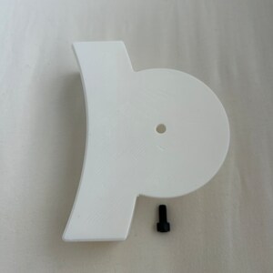 May include: White plastic 3D printed part with a round hole and a small black screw.