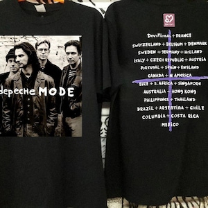 以下が含まれることがあります： 黒いTシャツ。Depeche Modeの白黒画像と白いバンド名がプリントされています。背中にはフランスやスイスなど、ツアーの開催地が記載されています。音楽をテーマにしたアイテムです。