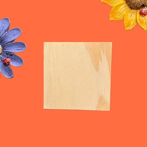 May include: A light orange background with a wooden square sign in the centre. A purple flower with a ladybug on it is on the left side of the image. A yellow sunflower with ladybugs on it is on the right side of the image.