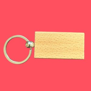 May include: A wooden keychain with a blank rectangular tag attached to a silver metal ring.