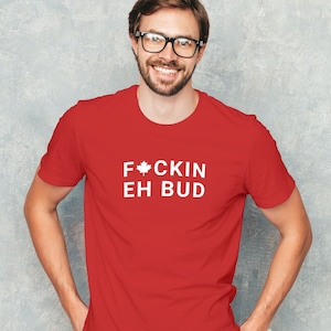 May include: Red t-shirt with white text that says "F*CKIN EH BUD" and a white maple leaf symbol.