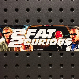 Pode incluir: Um adesivo com fundo branco e texto preto que diz "2 Fat 2 Curious" com um e comercial vermelho. O adesivo apresenta uma foto de três pessoas do filme "2 Fast 2 Furious".