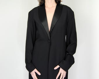 May include: A black long-sleeved blazer with a satin lapel. The blazer has a single button closure and a straight hem.