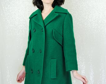 May include: A double-breasted green wool coat with a collar and pockets.