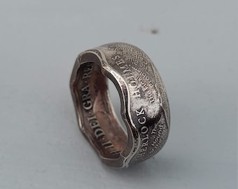 以下が含まれることがあります： 「SHERLOCK HOLMES」と「The Hound of the Carbuncle」の刻印が外側に、内側に「AI DEI GRA RE」の刻印が施された、再利用されたコインで作られた銀の指輪です。