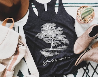 May include: A dark gray tank top with a white tree graphic and the text "God is in me".