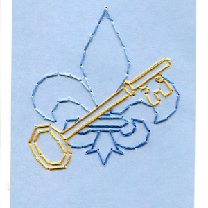 May include: A blue embroidered fleur-de-lis with a gold embroidered key.