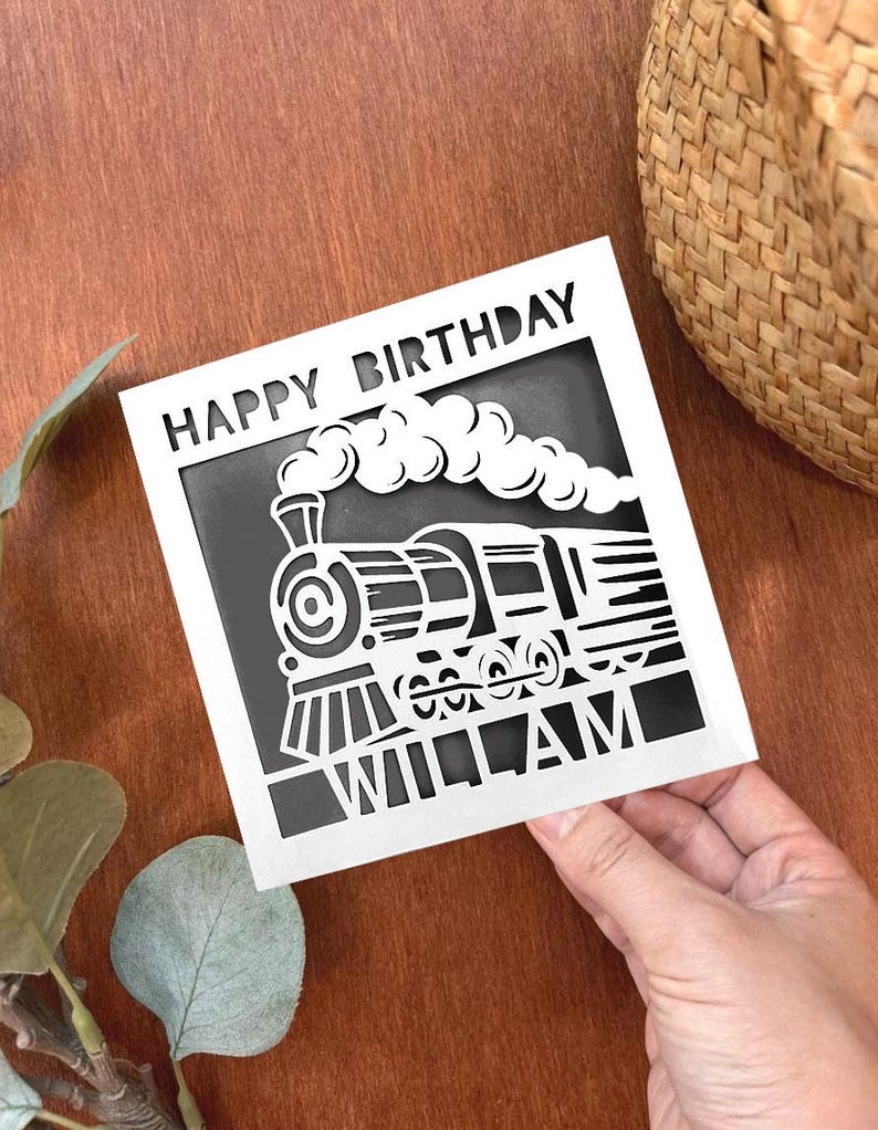 May include: White card with black cut-out design of a train with smoke and the words "Happy Birthday William".