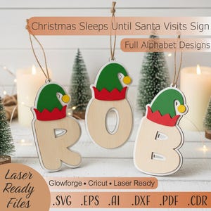 Puede incluir: Adornos navideños de madera que deletrean la palabra "ROB". Cada letra está adornada con un gorro de elfo verde con borde rojo y pompón amarillo. Archivos listos para láser.