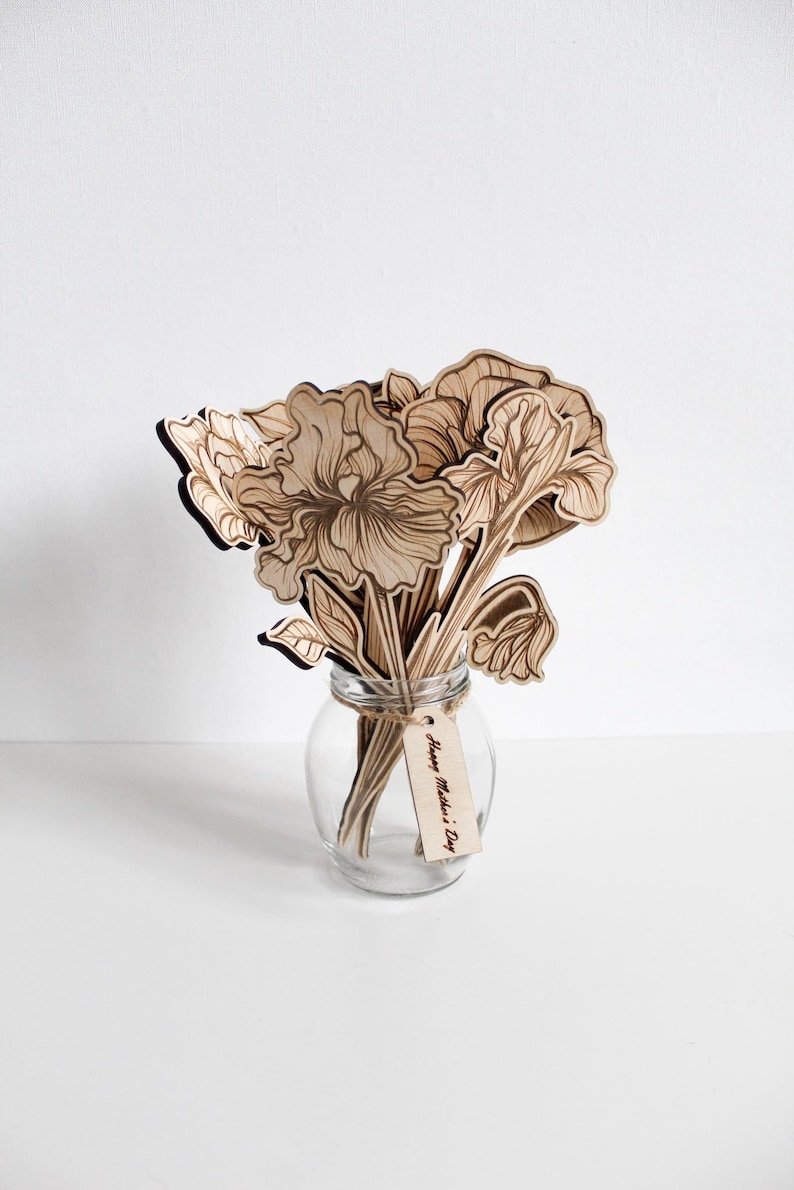 May include: A wooden bouquet of flowers in a clear glass vase with a tag that reads "Happy Mother's Day".