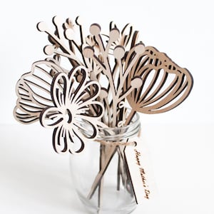 May include: A wooden bouquet of flowers in a clear glass jar with a tag that reads "Happy Mother's Day".