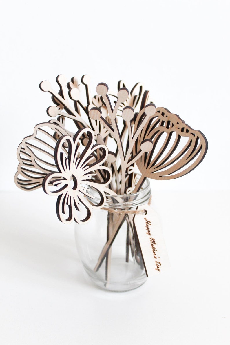 May include: A wooden bouquet of flowers in a clear glass jar with a tag that reads "Happy Mother's Day".