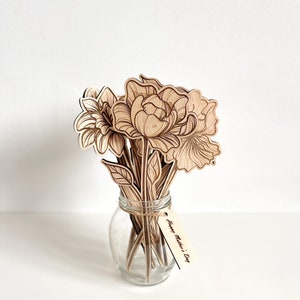 May include: A bouquet of laser-cut wooden flowers in a clear glass vase with a wooden tag that reads "Happy Mother's Day".