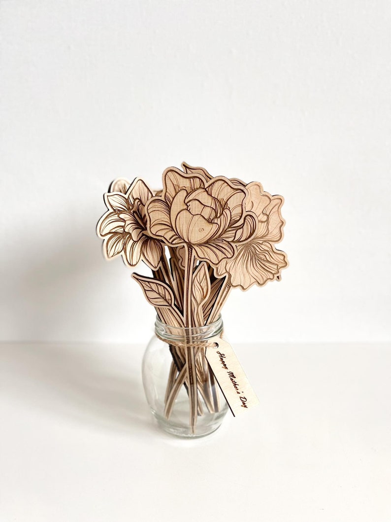 May include: A bouquet of laser-cut wooden flowers in a clear glass vase with a wooden tag that reads "Happy Mother's Day".