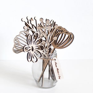 May include: A wooden bouquet of flowers in a clear glass vase with a tag that reads "Happy Mother's Day".