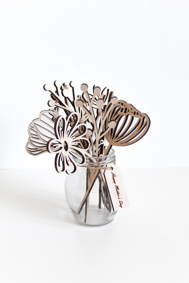 May include: A wooden bouquet of flowers in a clear glass vase with a tag that reads "Happy Mother's Day".