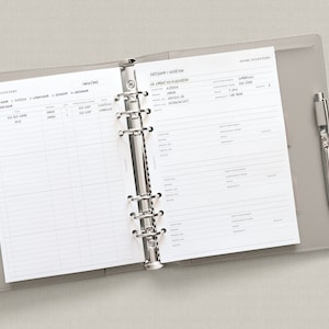 May include: A gray home inventory binder with a silver ring mechanism. The binder has two pages open, one with a list of categories and locations, and the other with a home inventory form. The form includes fields for date purchased, purchased from, price, and warranty.