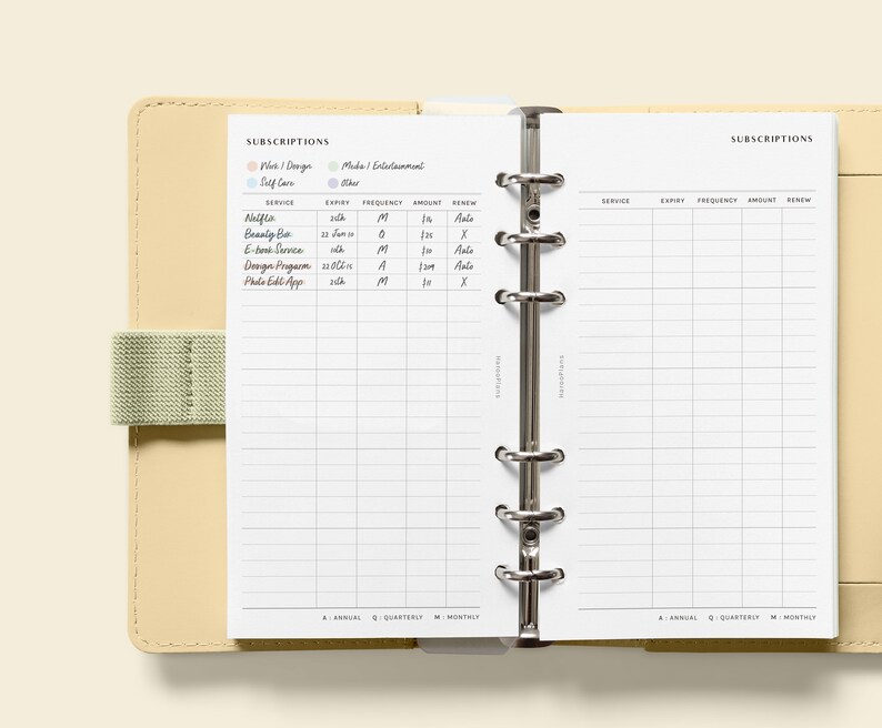 May include: A white planner with a beige leather cover and a silver ring binder. The planner has two pages open, both labeled "Subscriptions". The left page has a section for "Needs / Hygiene / Self Care" and "Media / Entertainment / Other". The right page has columns for "Service", "Expiry", "Frequency", "Amount", and "Renew".