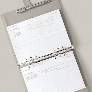 Puede incluir: Un archivador gris con una p&aacute;gina blanca abierta a una l&iacute;nea de tiempo del proyecto. La p&aacute;gina tiene una cuadr&iacute;cula con columnas para las fechas y filas para las tareas. La p&aacute;gina est&aacute; etiquetada como "Project Timeline" y tiene una secci&oacute;n para "Design Project" y otra para "Launch Project".