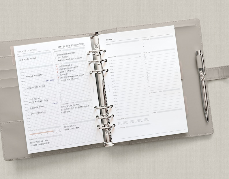 May include: A gray leather bound planner with a silver binder ring system. The planner is open to a daily page with a to-do list and a section for priorities. The page is dated "Today is..." and includes the text "Don't be busy, be productive!"