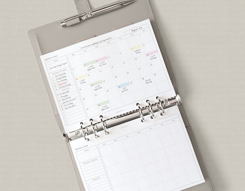 May include: A gray leather bound planner with a silver binder ring system. The planner has a monthly calendar view for August 2023 with handwritten appointments. The planner also has a monthly plan section with a list of goals and tasks.