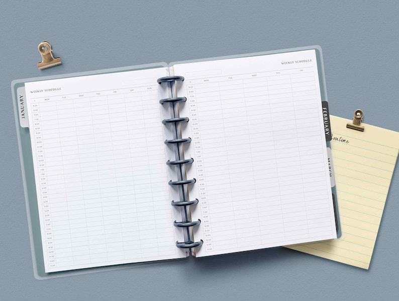 Puede incluir: Una agenda semanal con una cubierta de pl&aacute;stico transparente y una encuadernaci&oacute;n en espiral negra. La agenda tiene pesta&ntilde;as para enero y febrero. La agenda est&aacute; abierta en una p&aacute;gina en blanco con las palabras "Weekly Schedule" en la parte superior.