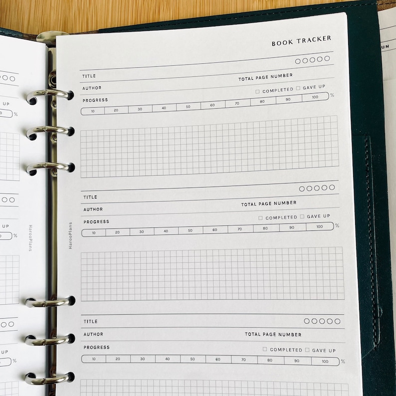 Op de afbeelding: Een witte boekentracker met een zwart rasterpatroon en de woorden "BOOK TRACKER" bovenaan. De boekentracker heeft secties voor titel, auteur, totaal aantal pagina's, voortgang, voltooid en opgegeven.