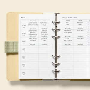 May include: A weekly meal planner with a white background and black text. The planner is divided into sections for breakfast, lunch, dinner, and snacks. Each day of the week is listed, along with the date. The planner includes a section for recording the calories for each meal.