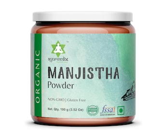 May include: A brown glass jar with a white lid containing Manjistha Powder. The label is green and white with the text "ORGANIC", "ayurvedix", "MANJISTHA Powder", "NON-GMO | Gluten Free", "Net. Qty. 100 g (3.52 Oz)", and a "fssai" logo.