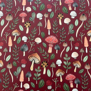 May include: A red background with a repeating pattern of mushrooms in various colors and styles. The mushrooms are drawn in a whimsical style with some having white spots and others having a more realistic look.
