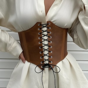Elevate your style with our Underbust leather corset, a handmade wide leather corset belt crafted from premium leather. Perfect for renaissance fairs, festivals, or modern outfits, this leather cincher belt flatters the waist and adds bold elegance. Adjustable for comfort, it’s a unique blend of history and fashion—an accessory that transforms any look.