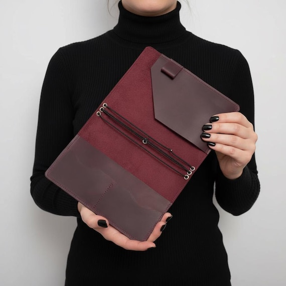 Engraved leather journal cover with a built-in pen holder and 1,092 favorites — this is the most functional and validated design in the entire batch.