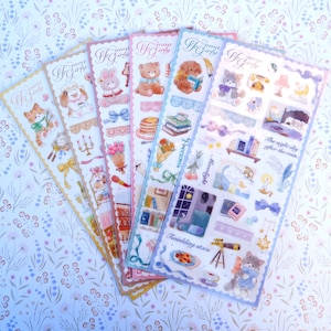 May include: A set of six sheets of colorful stickers featuring illustrations of animals, books, and other cute objects. The stickers are designed in a whimsical style with a pastel color palette. The text on the stickers reads "Go Girly".