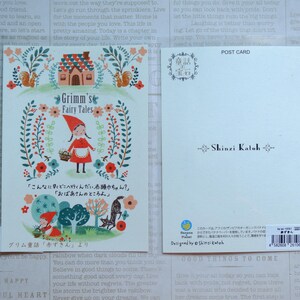 May include: A postcard featuring a colorful illustration of Little Red Riding Hood walking through a forest with a basket of flowers. The text "Grimm's Fairy Tales" is written in a whimsical font. The back of the postcard has a Japanese text and the name "Shinzi Katoh" printed in black.
