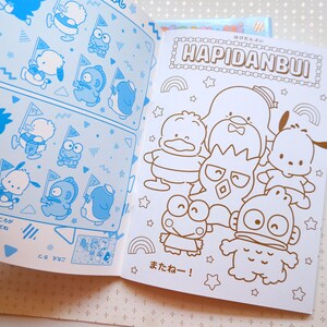 May include: A coloring book featuring a group of cartoon characters, including a penguin, a frog, and a bear. The book is titled "Hapidanbui" and has a rainbow design. The characters are outlined in black and ready to be colored in.